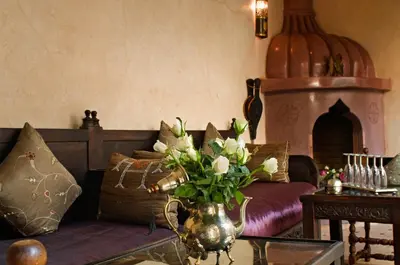 a living room with a couch and a vase of flowers at Riad Papillon by Marrakech Riad in Marrakech
