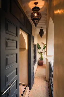 a hallway with a door and a chandelier at Riad Papillon by Marrakech Riad in Marrakech