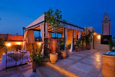 a house with a patio with a table and chairs at Riad Cinnamon by Marrakech Riad in Marrakech