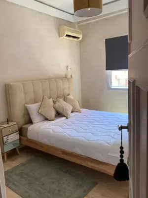a bedroom with a large bed with blue sheets and a window at Comme à la maison, en plein coeur de Marrakech in Marrakech