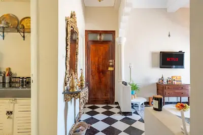 a kitchen with a wooden door and a checkered floor at Dar Noubti in Marrakech