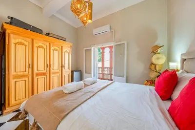 a bedroom with a large white bed with red pillows at Dar Noubti in Marrakech