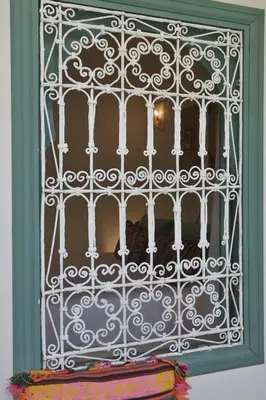 a window with a white iron gate with a pillow at Riad NaaNaa Bed & Breakfast in Marrakech
