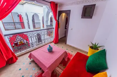 a living room with a table and a balcony at Riad Khabia & Spa in Marrakech