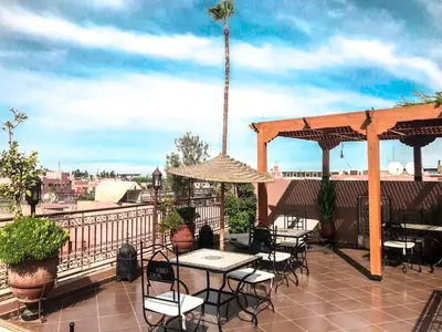 a patio with tables and chairs on a balcony at Riad Hôtel Marraplace in Marrakech