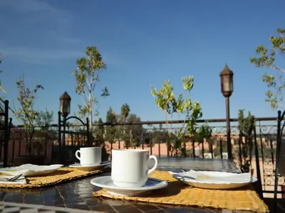 a table with two coffee cups and plates on it at Riad Hôtel Marraplace in Marrakech