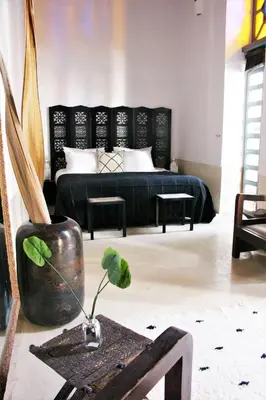 a bedroom with a black bed and a potted plant at Riad El Ouarda in Marrakech