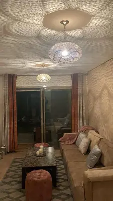 a living room with a couch and a chandelier at Marrakech Prestigia Jade Golf Piscine in Marrakech