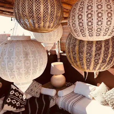 a room with chandaliers and a bed and a lamp at Riad Chocolat in Marrakech