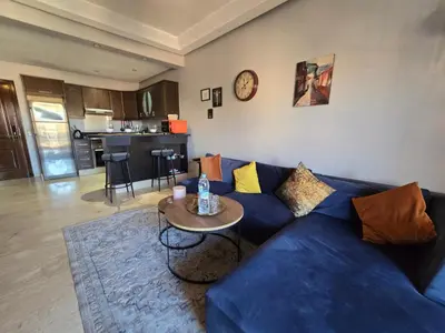 a living room with a blue couch and a table at Cosy Bagatelle Houses 1 & 2 in Marrakech