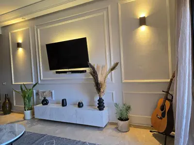 a living room with a flat screen tv on a wall at Cosy Bagatelle Houses 1 & 2 in Marrakech