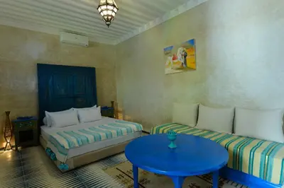 a room with two beds and a blue table at Casa De Marrakech Riad Guest House in Marrakech