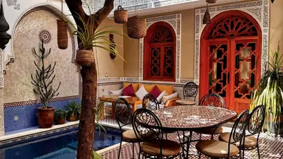 a patio with a table and chairs next to a pool at RIAD SHAJARA in Marrakech