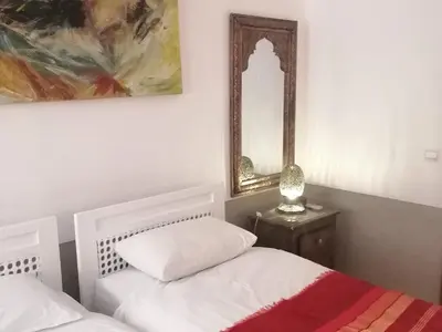 a bedroom with two white beds and a mirror at Dar 14 Marrakech in Marrakech