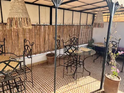 a patio with chairs and a table in a tent at RIAD RIME QOUSSAI in Marrakech