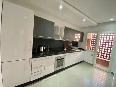 a kitchen with white cabinets and black counter tops at RIAD GARDEN LUXURY AGDAL in Marrakech