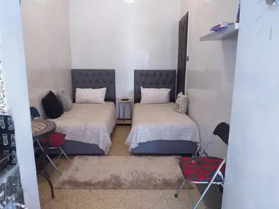 a room with two beds and chairs in it at studio Dar Rmila in Marrakech
