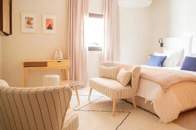 a bedroom with a bed and a chair at Le Pavillon de la Kasbah & SPA Marrakech in Marrakech