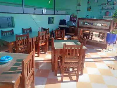a restaurant with wooden tables and chairs in a room at DAR AZIZ in Marrakech