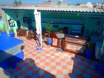 a patio with potted plants on a checkered floor at DAR AZIZ in Marrakech