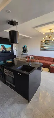 a kitchen with a sink and a living room at Luxueux appartement entre Gueliz et l'Hivernage avec WIFI in Marrakech