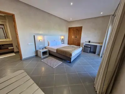 a large bedroom with a bed and a bathroom at Le Parc des Oliviers Ecolodge in Marrakech