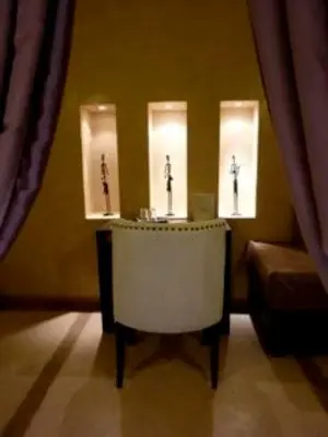 a room with a table with three lights and a couch at Riad Hermès in Marrakech