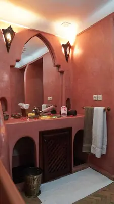a bathroom with a sink and a large mirror at Riad Ahlsouss in Marrakech