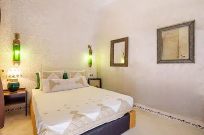 a bedroom with a large white bed and a mirror at Riad 7 chambres - Petit dejeuner gratuit in Marrakech