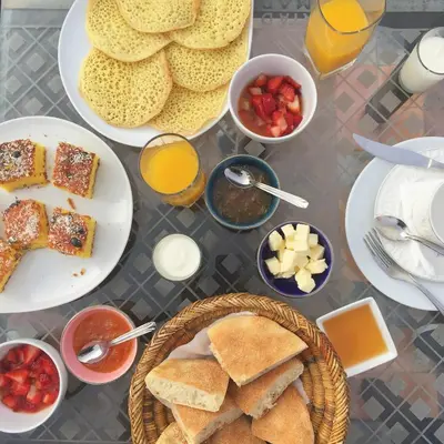 a table with plates of breakfast foods and drinks at Riad Zarka By La Siredrah in Marrakech
