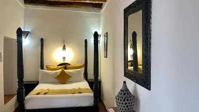 a bedroom with a bed with a large mirror at Riad Zarka By La Siredrah in Marrakech