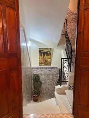 a hallway with stairs with a potted plant at Cosy appartement in Marrakech