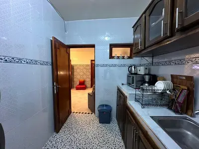 a small kitchen with a sink and a door at Cosy appartement in Marrakech