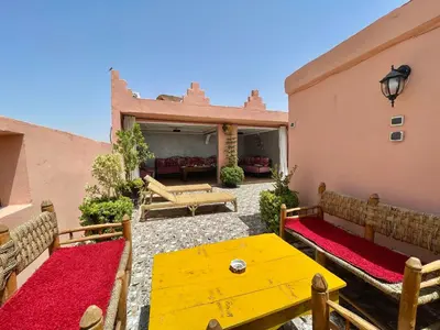 a patio with a yellow table and benches at Cosy appartement in Marrakech
