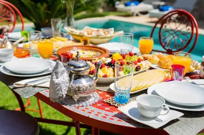 a table with a breakfast of food and orange juice at VILLA MARIA - Famille uniquement in Marrakech