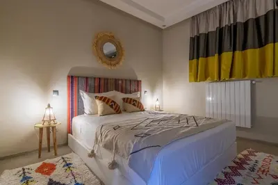 a bedroom with a large bed and a mirror at VILLA MARIA - Famille uniquement in Marrakech