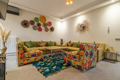 a living room with two couches and a table at VILLA MARIA - Famille uniquement in Marrakech