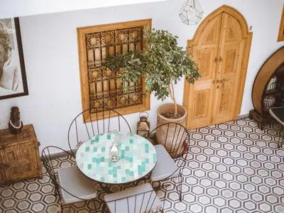 a room with a table and chairs and a door at Riad Le Petit Joyau in Marrakech