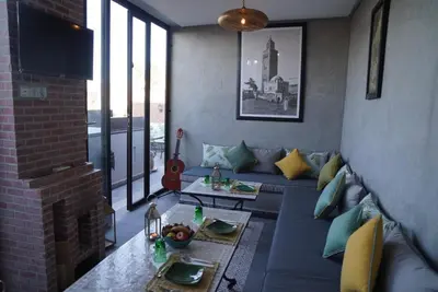 a living room with a blue couch and a fireplace at Riad Le Petit Joyau in Marrakech