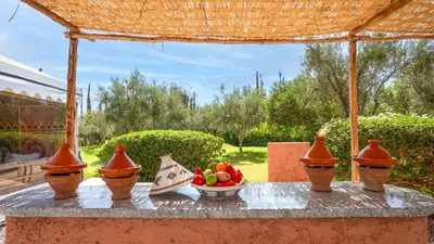 a table with a bowl of fruit and a bowl of vegetables at Ourika Camp Suites Hotel & Resort in Marrakech