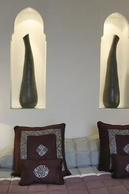 two black vases on the wall above a couch at Riad Assakina in Marrakech
