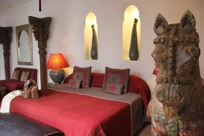 a bedroom with a bed with a red blanket at Riad Assakina in Marrakech