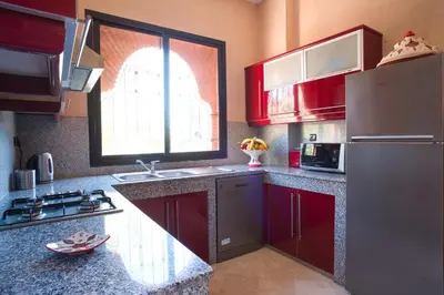 a kitchen with red cabinets and a large window at Villa Tilila in Marrakech