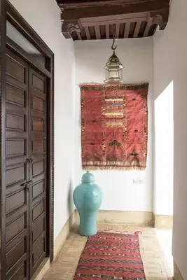 a blue vase sitting on a rug next to a door at Riad Hayati in Marrakech