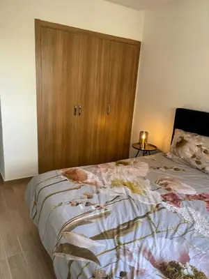 a bedroom with a bed with a wooden cabinet at La Perla de Marrakech Appart de Luxe in Marrakech