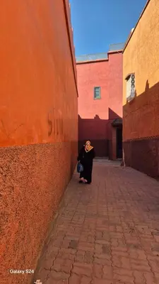 a woman standing in a alley next to a wall at Riad Dar Aida in Marrakech