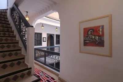 a hallway with stairs and a painting on the wall at Riad Dar Safi, privatise 6 à 8 pers, bain exterieur in Marrakech