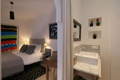 a bedroom with a bed and a sink and a bed at Riad Dar Safi, privatise 6 à 8 pers, bain exterieur in Marrakech