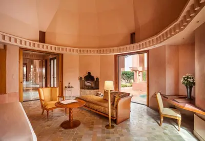 a living room with a bed and a table and chairs at Amanjena Resort in Marrakech