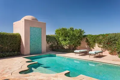 a swimming pool in the middle of a yard at Amanjena Resort in Marrakech